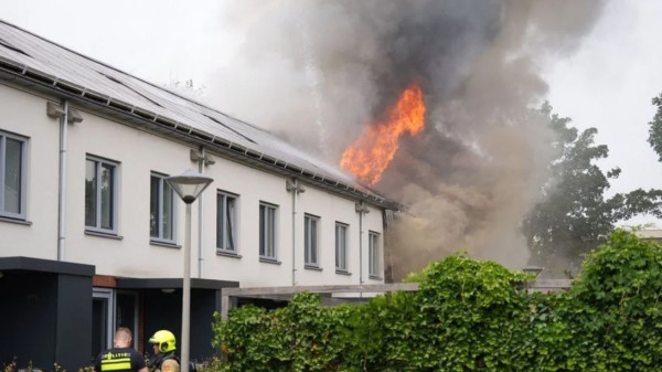 Uitslaande brand bij een rij verduurzaamde woningen met doorlopende zonnepanelen in Arnhem op 18-6-2023.