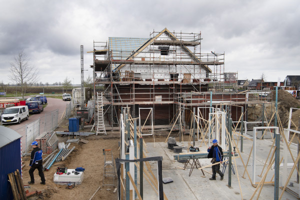 Vier ploegen van twee timmerlieden bouwen de woningen: één ploeg voor de fundering, twee ploegen voor het stellen, één ploeg die aftimmert.